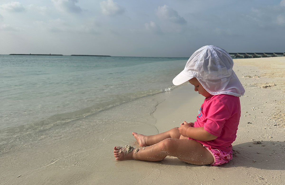 Unsere-Flitterwochen-mit-Baby-im-Amari-Raaya-Malediven-malediven-inseln-im-sand-sitzen